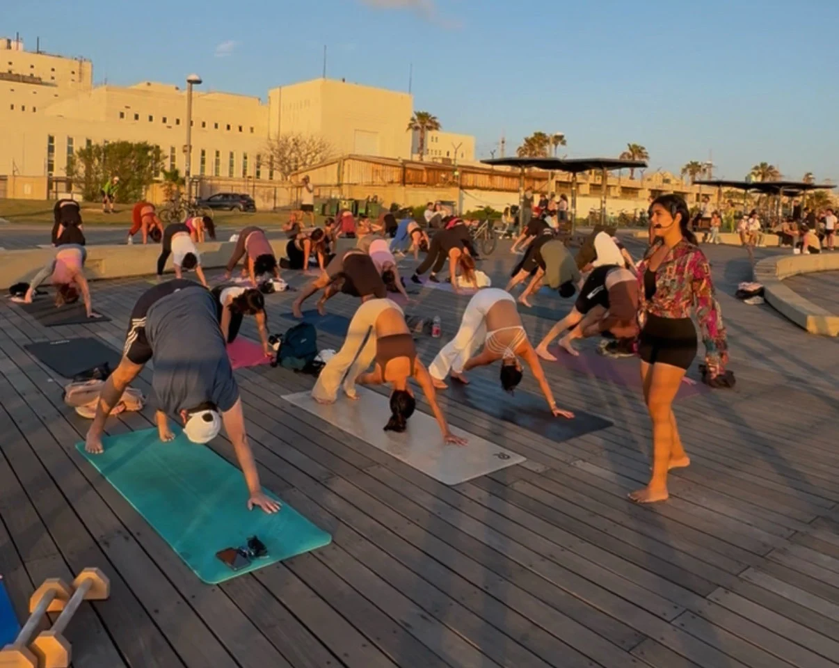 Rebecca Mardi guidant une séance de yoga thérapeutique en extérieur pour un groupe.